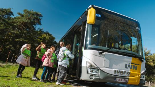 Kinderen stappen op de bus terug naar school.